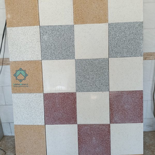نمای دور از تابلو محصولات اصفهان موزاییک که چندین موزاییک سنگ نمره ریز رنگی بر روی آن قرار گرفته است