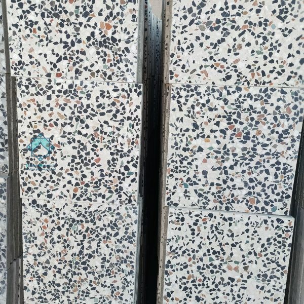تصویر نمای نزدیک از چند موزاییک طوسی اراکی سنگ ریز که بر روی دسته قرار گرفته‌اند