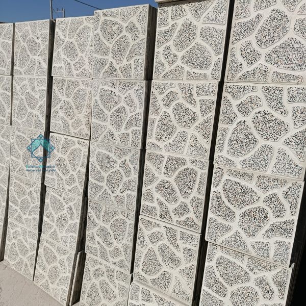 نمای مورب و دور از چندین دسته موزاییک حیاطی زمینه قرمز با سنگ‌های سفید و مشکی که بر روی هم قرار گرفته‌اند. این موزاییک‌ها با نظم و یکنواخت در کنار یکدیگر چیده شده‌اند