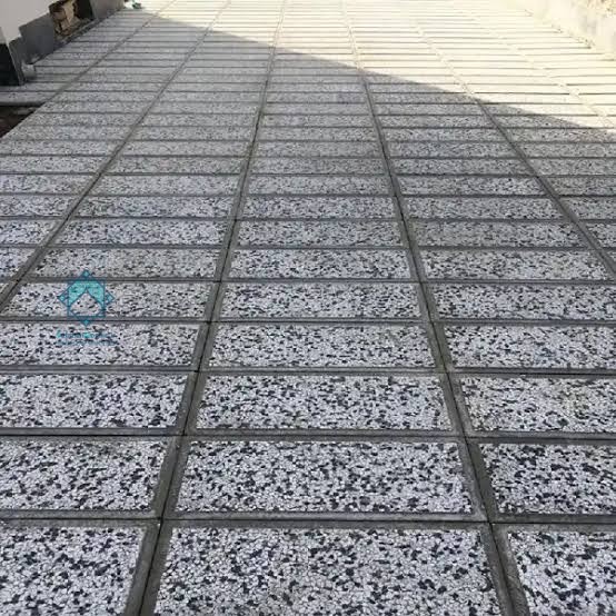 نمای اجرا شده موزاییک واش بتن 30 در 60 ترکی که بین هر موزاییک با چمن مصنوعی پوشش داده شده است